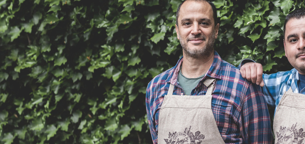 Amy's employees standing in front a large hedge